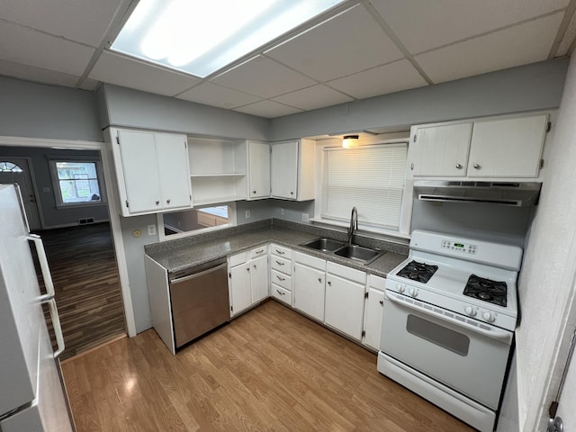 937 S Holmes St, Lansing, MI 48912 - kitchen with white appliances, a sink, under cabinet range hood, a paneled ceiling, and dark countertops