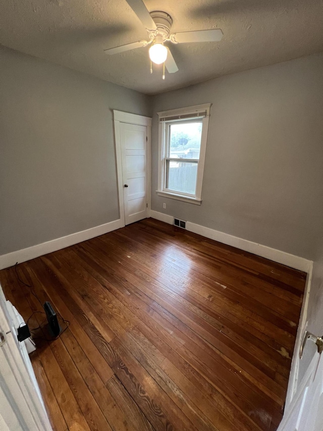 937 S Holmes St, Lansing, MI 48912 - unfurnished room with dark wood finished floors, baseboards, ceiling fan, and a textured ceiling