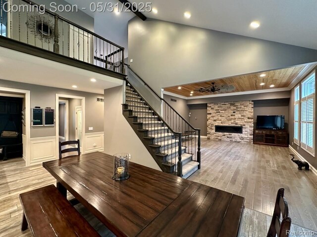 52006 Finch Ct, Shelby Twp, MI 48315 - unfurnished dining area with wood finished floors, stairway, a stone fireplace, a ceiling fan, and recessed lighting