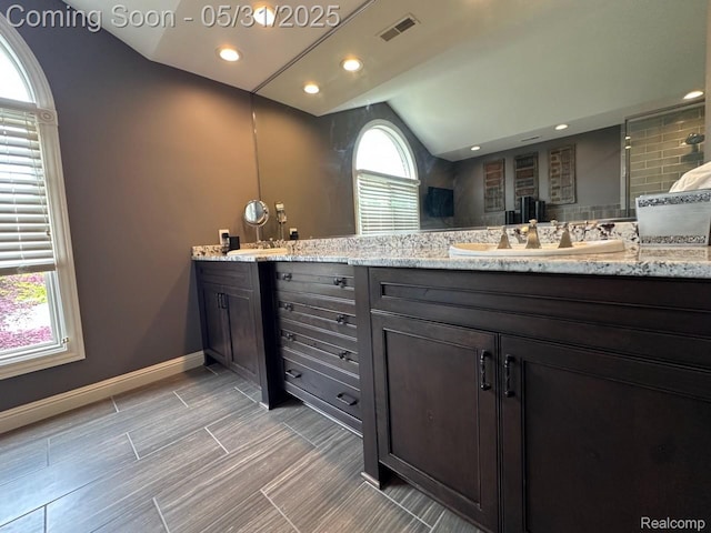 52006 Finch Ct, Shelby Twp, MI 48315 - bathroom featuring double vanity, lofted ceiling, baseboards, recessed lighting, and tiled shower