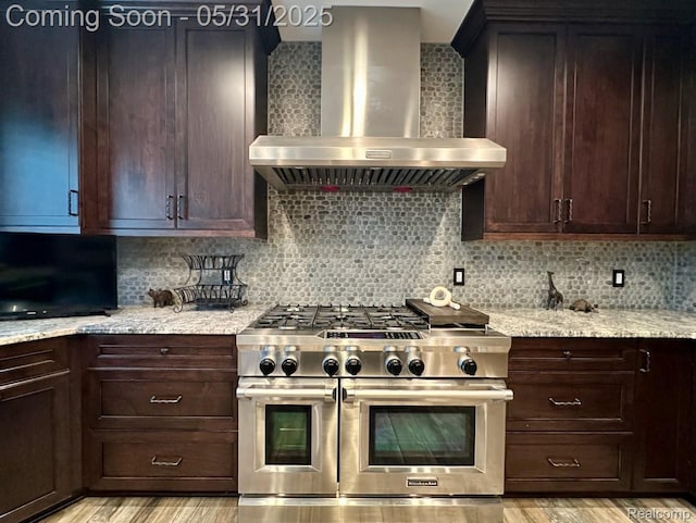 52006 Finch Ct, Shelby Twp, MI 48315 - kitchen featuring wall chimney exhaust hood, range with two ovens, light wood finished floors, and backsplash