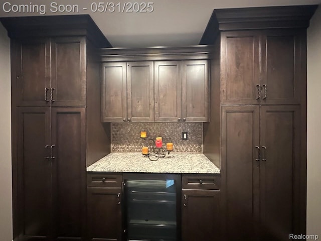 52006 Finch Ct, Shelby Twp, MI 48315 - kitchen featuring wine cooler, backsplash, dark brown cabinets, and light stone countertops