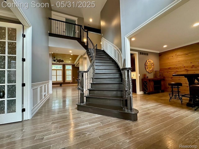 52006 Finch Ct, Shelby Twp, MI 48315 - staircase with ornamental molding, a high ceiling, wood finished floors, recessed lighting, and wood walls