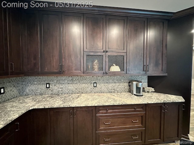 52006 Finch Ct, Shelby Twp, MI 48315 - kitchen featuring decorative backsplash, light stone countertops, and dark brown cabinets