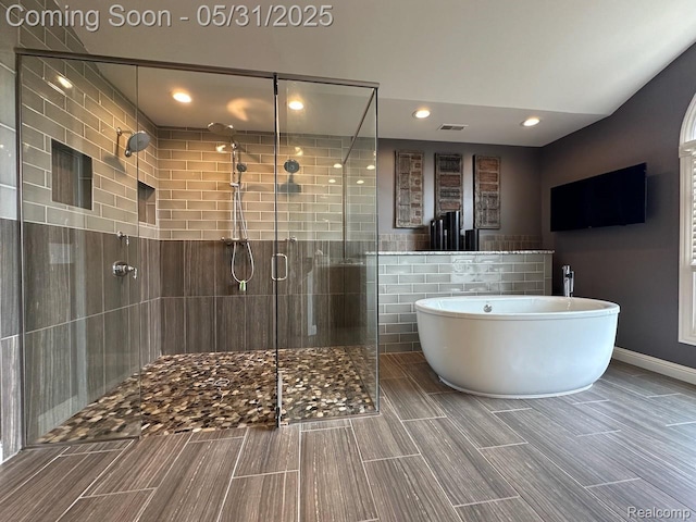 52006 Finch Ct, Shelby Twp, MI 48315 - bathroom featuring a freestanding bath, a stall shower, recessed lighting, and tile walls