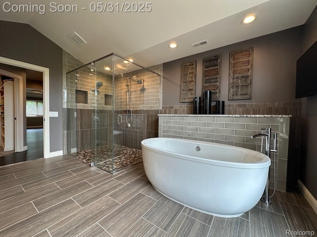 52006 Finch Ct, Shelby Twp, MI 48315 - bathroom featuring tile walls, a freestanding tub, a stall shower, vaulted ceiling, and recessed lighting