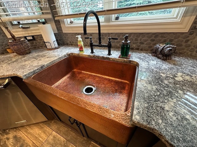 52006 Finch Ct, Shelby Twp, MI 48315 - kitchen view of stainless steel dishwasher, tasteful backsplash, a sink, and stone counters