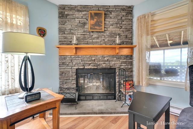 5777 N Broadway, Freeport, MI 49325 - living room featuring wood finished floors, baseboard heating, and a fireplace