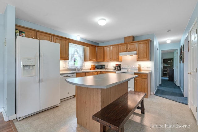 5777 N Broadway, Freeport, MI 49325 - kitchen with white appliances, under cabinet range hood, a sink, a center island, and light countertops