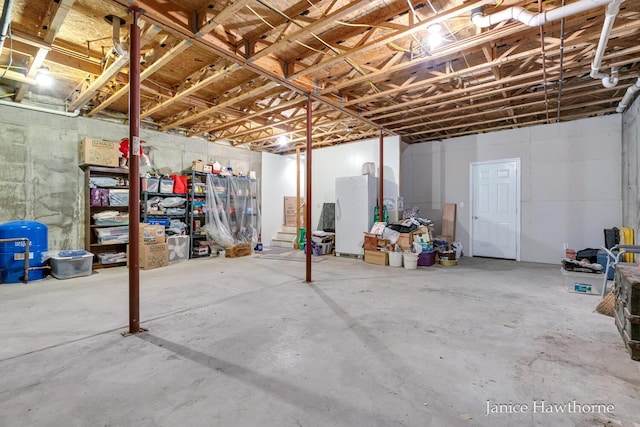 5777 N Broadway, Freeport, MI 49325 - unfinished below grade area featuring a water pressure tank and freestanding refrigerator