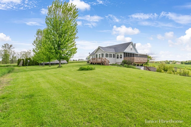 5777 N Broadway, Freeport, MI 49325 - view of grassy yard with a deck and a sunroom