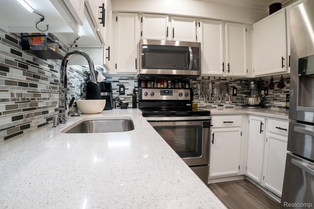 4241 Schaefer Rd, Dearborn, MI 48126 - kitchen with stainless steel appliances, a sink, decorative backsplash, and white cabinetry
