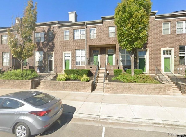 4241 Schaefer Rd, Dearborn, MI 48126 - townhome / multi-family property with a chimney, brick siding, and stairway
