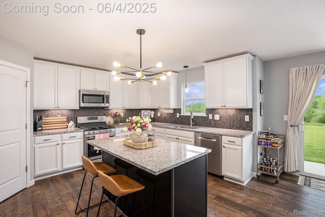13210 River Bend Dr, Linden, MI 48451 - kitchen with stainless steel appliances, a sink, a chandelier, and dark wood-type flooring