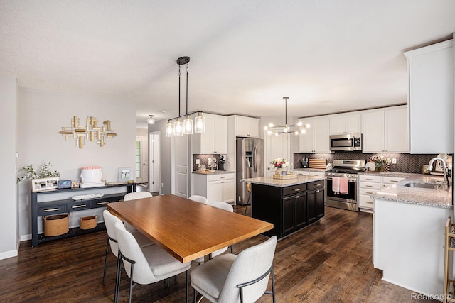 13210 River Bend Dr, Linden, MI 48451 - kitchen featuring appliances with stainless steel finishes, a sink, tasteful backsplash, and dark wood finished floors