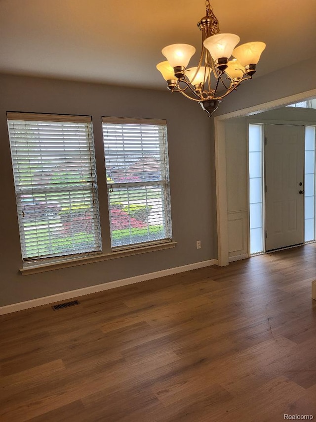 49515 Crusader, Macomb, MI 48044 - unfurnished room with a chandelier, baseboards, plenty of natural light, and wood finished floors