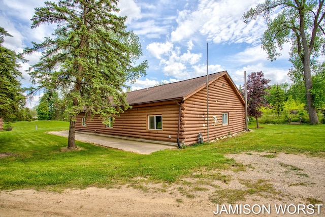 4403 4th St, Caledonia, MI 49316 - view of side of property featuring a patio area, log exterior, a yard, and a shingled roof