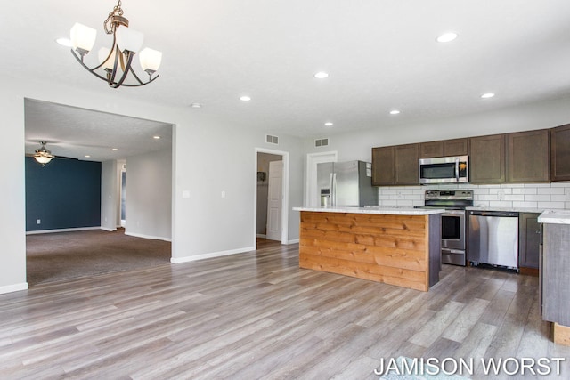 4403 4th St, Caledonia, MI 49316 - kitchen featuring appliances with stainless steel finishes, light countertops, recessed lighting, light wood-style floors, and a center island