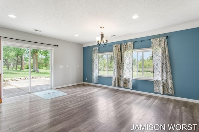 4403 4th St, Caledonia, MI 49316 - unfurnished room with a chandelier, wood finished floors, a textured ceiling, baseboards, and recessed lighting