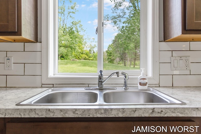 4403 4th St, Caledonia, MI 49316 - kitchen view of a sink, light countertops, tasteful backsplash, and dark brown cabinetry