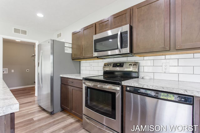 4403 4th St, Caledonia, MI 49316 - kitchen with appliances with stainless steel finishes, light countertops, backsplash, light wood-style floors, and recessed lighting