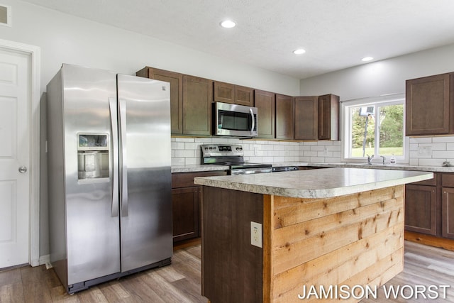 4403 4th St, Caledonia, MI 49316 - kitchen featuring appliances with stainless steel finishes, light wood-type flooring, recessed lighting, backsplash, and light countertops