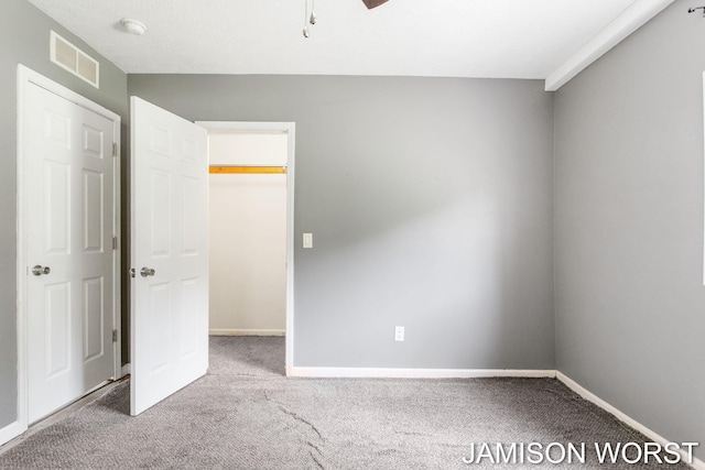 4403 4th St, Caledonia, MI 49316 - unfurnished bedroom with carpet, baseboards, a walk in closet, and a ceiling fan