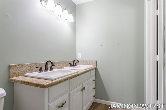 4403 4th St, Caledonia, MI 49316 - bathroom with double vanity, toilet, and wood finished floors