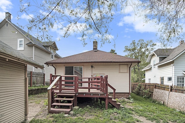 205 Corinne St SW, Grand Rapids, MI 49507 - rear view of property featuring a fenced backyard, a wooden deck, and a chimney