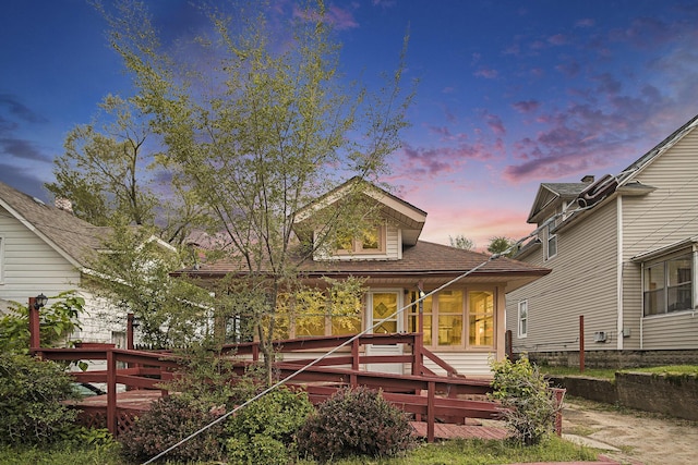205 Corinne St SW, Grand Rapids, MI 49507 - back of house at dusk with a wooden deck and roof with shingles