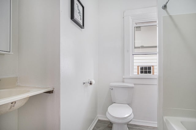 205 Corinne St SW, Grand Rapids, MI 49507 - bathroom with toilet, baseboards, a bath, wood finished floors, and a shower
