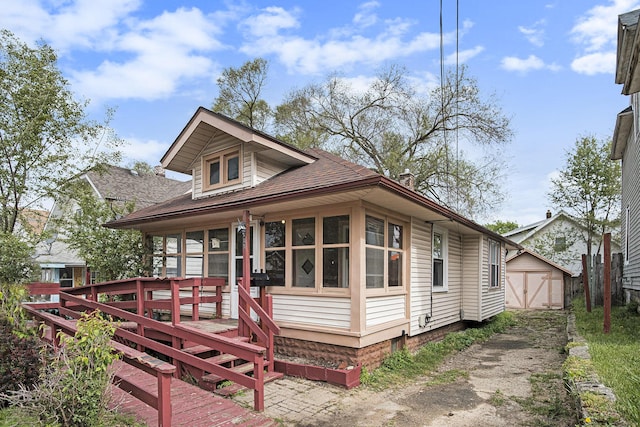 205 Corinne St SW, Grand Rapids, MI 49507 - view of front facade featuring a deck, roof with shingles, and a sunroom