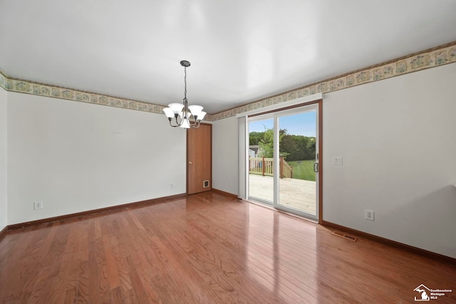 214 Roosevelt St, Dundee, MI 48131 - spare room with a chandelier, baseboards, and wood finished floors