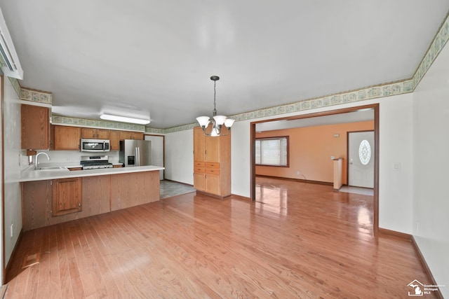 214 Roosevelt St, Dundee, MI 48131 - kitchen featuring stainless steel appliances, a peninsula, light wood-style floors, a sink, and light countertops