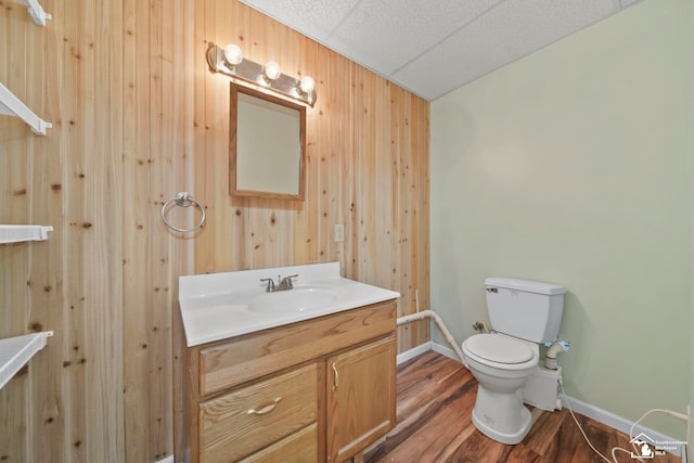 214 Roosevelt St, Dundee, MI 48131 - half bathroom with wooden walls, vanity, toilet, baseboards, and wood finished floors