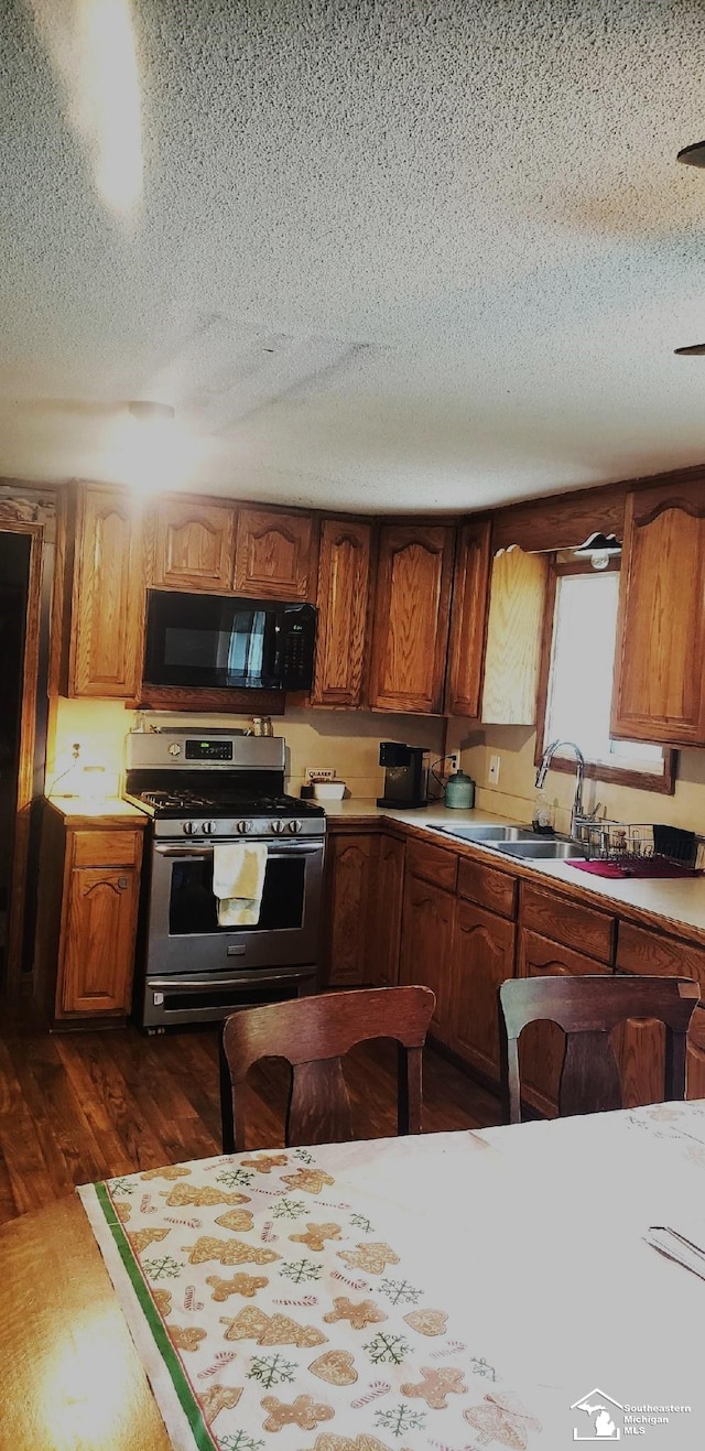 9361 Exeter Rd, Carleton, MI 48117 - kitchen with stainless steel range with gas stovetop, black microwave, a textured ceiling, a sink, and light countertops