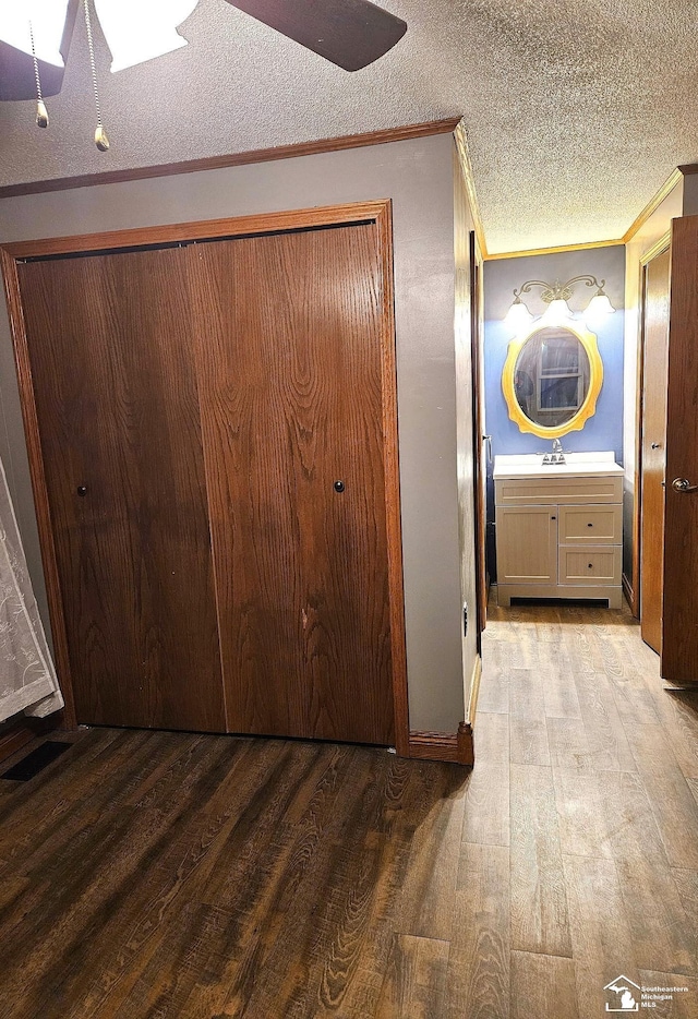 9361 Exeter Rd, Carleton, MI 48117 - hallway featuring wood finished floors, ornamental molding, a textured ceiling, and a skylight
