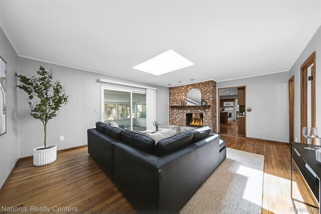 892 Hemlock Ct, Rochester, MI 48307 - living area featuring a skylight, hardwood / wood-style flooring, a brick fireplace, ornamental molding, and baseboards