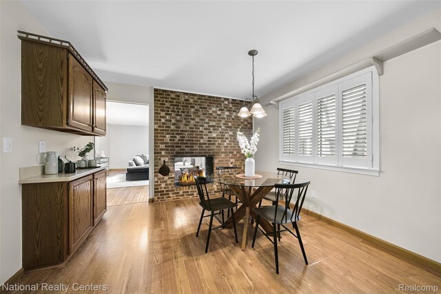 892 Hemlock Ct, Rochester, MI 48307 - dining space with light wood-style floors, a fireplace, and a chandelier