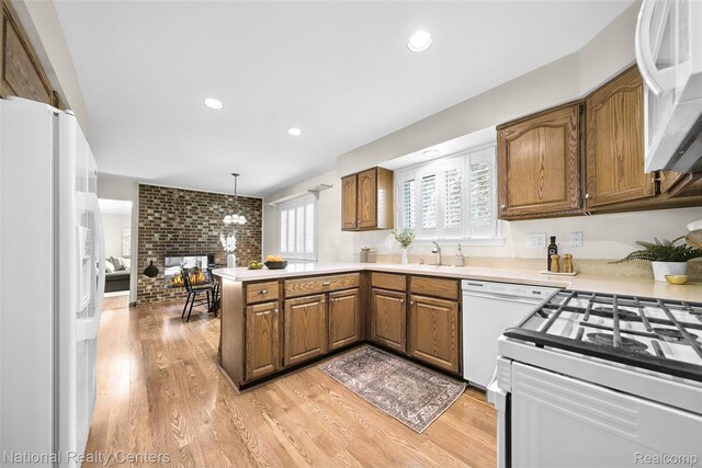 892 Hemlock Ct, Rochester, MI 48307 - kitchen featuring white appliances, a peninsula, brown cabinetry, light countertops, and brick wall