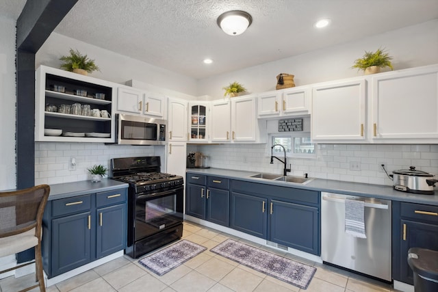 1645 College Ave SE, Grand Rapids, MI 49507 - kitchen featuring stainless steel appliances, blue cabinets, a sink, recessed lighting, and a textured ceiling