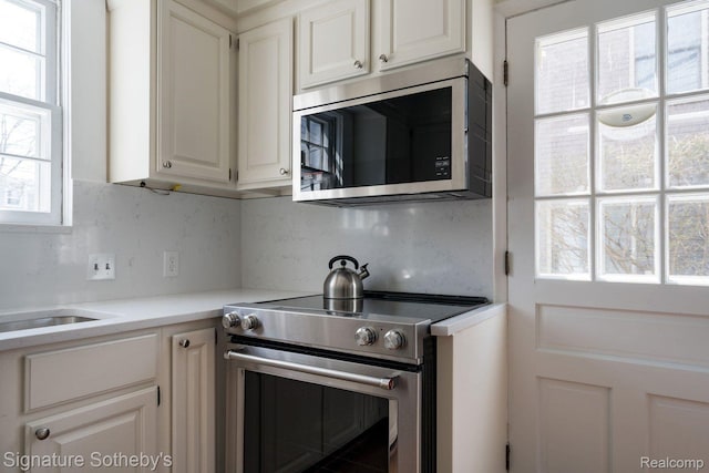 1205 S Bates St, Birmingham, MI 48009 - kitchen with stainless steel appliances, decorative backsplash, light countertops, and white cabinetry