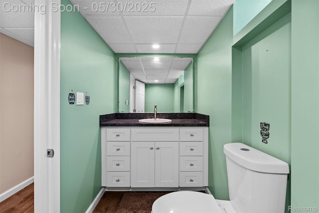 25305 Ursuline St, Saint Clair Shores, MI 48081 - half bathroom with toilet, a paneled ceiling, vanity, wood finished floors, and baseboards