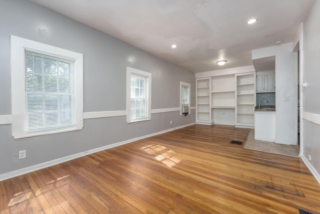 617 Wheaton Ave, Kalamazoo, MI 49008 - unfurnished living room with a sink, healthy amount of natural light, wood finished floors, and recessed lighting