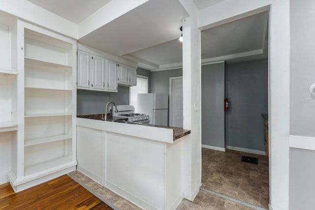 617 Wheaton Ave, Kalamazoo, MI 49008 - kitchen with white appliances, open shelves, dark countertops, white cabinetry, and a peninsula