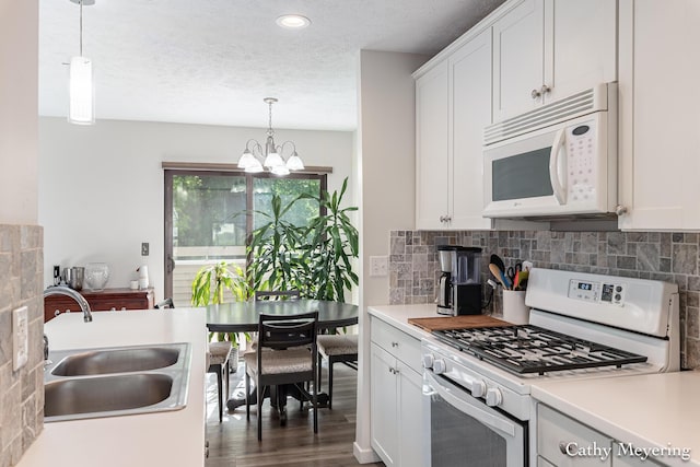 6387 Wainscot Dr SE Unit 102, Grand Rapids, MI 49546 - kitchen featuring white appliances, a sink, a chandelier, backsplash, and a textured ceiling
