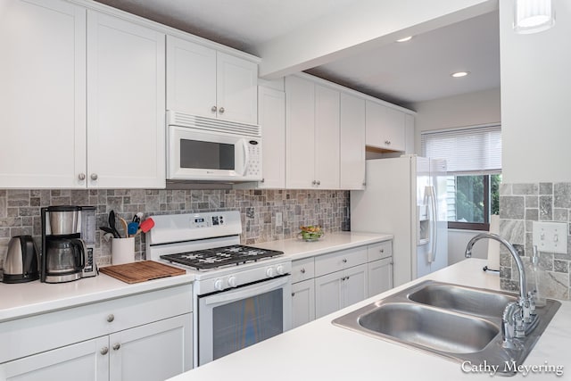 6387 Wainscot Dr SE Unit 102, Grand Rapids, MI 49546 - kitchen with white appliances, a sink, white cabinetry, tasteful backsplash, and light countertops