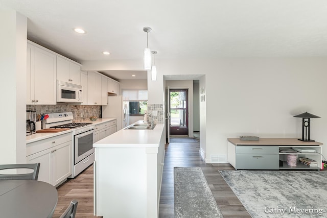 6387 Wainscot Dr SE Unit 102, Grand Rapids, MI 49546 - kitchen with white appliances, a sink, white cabinetry, decorative backsplash, and recessed lighting