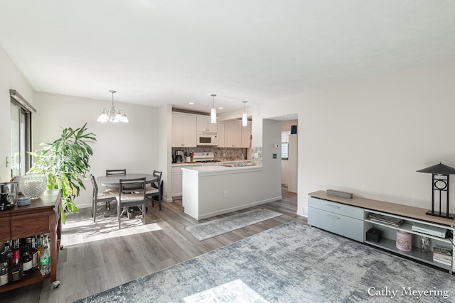 6387 Wainscot Dr SE Unit 102, Grand Rapids, MI 49546 - living area featuring a chandelier, light wood-type flooring, and baseboards