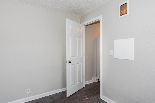 1226 Shakespeare Ave, Kalamazoo, MI 49001 - empty room featuring dark wood-style flooring, baseboards, and a textured ceiling